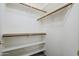 Spacious walk-in closet with wooden rods and shelves, offering ample storage and organization options at 1031 W Longhorn Dr, Chandler, AZ 85286