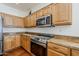 Modern kitchen features stainless steel appliances, granite countertops, and wooden cabinets at 1031 W Longhorn Dr, Chandler, AZ 85286