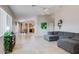Open-concept living room featuring tile floors, neutral walls, and a comfortable gray sectional sofa at 10334 E Diamond Ave, Mesa, AZ 85208