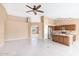 Open-concept living area features tile floors, a ceiling fan, and a kitchen with a center island at 10845 W Quail Ave, Peoria, AZ 85373