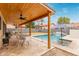 Outdoor dining area next to pool with covered patio and ceiling fan at 1231 W Mediterranean Dr, Gilbert, AZ 85233