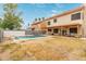 Expansive backyard featuring a sparkling pool, covered patio, and lush landscaping at 1231 W Mediterranean Dr, Gilbert, AZ 85233