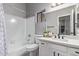 Bathroom featuring a shower over tub, window, and white vanity with black hardware at 1231 W Mediterranean Dr, Gilbert, AZ 85233