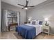 Bedroom with a ceiling fan, blue bedding, and a window with curtains for natural light at 1231 W Mediterranean Dr, Gilbert, AZ 85233