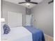 Bedroom featuring a ceiling fan, sliding door closet, and blue bedding with white details at 1231 W Mediterranean Dr, Gilbert, AZ 85233