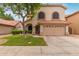 Inviting two-story home featuring a well-manicured lawn and a two-car garage with a red tile roof at 1231 W Mediterranean Dr, Gilbert, AZ 85233