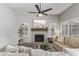 Comfortable living room with fireplace, neutral color palette, a ceiling fan and plantation shutters at 1231 W Mediterranean Dr, Gilbert, AZ 85233