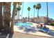 Resort style pool features lounge chairs, tables, seating and palm trees in a serene community setting at 14620 N Yerba Buena Way # B, Fountain Hills, AZ 85268