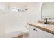 Bright bathroom with granite vanity, framed mirror, tub with shower, and wood-look floors at 15440 S 38Th St, Phoenix, AZ 85044