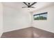 This bedroom features neutral paint, a ceiling fan, wood-look floors, and a window with outdoor views at 15440 S 38Th St, Phoenix, AZ 85044