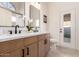 Bathroom featuring double sinks with a white countertop, wooden cabinets, and matte black fixtures at 1627 W Maplewood St, Chandler, AZ 85286