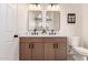 Bathroom featuring double sinks with a white countertop, wooden cabinets, and matte black fixtures at 1627 W Maplewood St, Chandler, AZ 85286