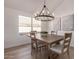 Bright dining room featuring a modern chandelier, wood table, comfortable chairs and large windows at 1627 W Maplewood St, Chandler, AZ 85286