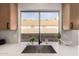 Kitchen sink featuring a large window with backyard views and white subway tile backsplash at 1627 W Maplewood St, Chandler, AZ 85286