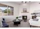 Bright living room featuring a fireplace, neutral chairs, a dark wood table, and large windows at 1627 W Maplewood St, Chandler, AZ 85286