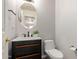 Stylish half-bathroom featuring a round mirror and custom vanity at 1925 W Olive Way, Chandler, AZ 85248