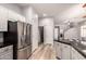 Well-lit kitchen with stainless steel refrigerator, stylish cabinets, and an open layout to the living area at 1925 W Olive Way, Chandler, AZ 85248