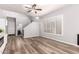 Open-concept living area with wood floors, modern wall unit, and ample natural light from large windows at 1925 W Olive Way, Chandler, AZ 85248