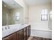 Bathroom featuring a dual-sink vanity, separate tub and glass shower, and large mirror at 20750 N 87 St # 2103, Scottsdale, AZ 85255