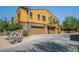 Modern exterior showcasing a yellow townhome with stone accents, multiple garage doors, and well-maintained landscaping at 20750 N 87 St # 2103, Scottsdale, AZ 85255