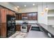 Well-equipped kitchen featuring black appliances, dark wood cabinets, and ample counter space at 20750 N 87 St # 2103, Scottsdale, AZ 85255