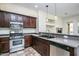 Modern kitchen with stainless steel appliances, dark wood cabinetry, and gray countertops at 20750 N 87 St # 2103, Scottsdale, AZ 85255