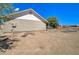Back view of the house with dirt yard, blue skies and a view of desert landscape at 22222 W Lower Buckeye Rd, Buckeye, AZ 85326
