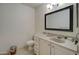 A clean bathroom featuring a vanity with a sink, a toilet, and a large mirror at 22222 W Lower Buckeye Rd, Buckeye, AZ 85326