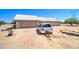 Single story home with a light colored roof and stucco walls, on a large dirt lot with car parked out front at 22222 W Lower Buckeye Rd, Buckeye, AZ 85326