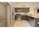 Kitchen features stainless steel appliances, dark cabinets, laminate countertops, and tile flooring at 22222 W Lower Buckeye Rd, Buckeye, AZ 85326