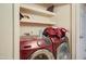 Image of a laundry room featuring a red Samsung washer and dryer, along with overhead shelving for storage at 22222 W Lower Buckeye Rd, Buckeye, AZ 85326