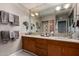 Bathroom with double sinks, oak cabinets, decorative mirror, and modern lighting at 2319 N 58Th St, Scottsdale, AZ 85257
