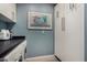 Laundry room features white cabinets, washer, dryer and an abstract art piece on a blue wall at 2319 N 58Th St, Scottsdale, AZ 85257
