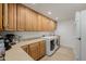 Laundry room with lots of wood cabinets for storage and white appliances at 2350 E Melrose St, Gilbert, AZ 85297
