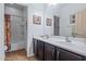 Bathroom showcasing a double sink vanity, shower/tub combo, tile flooring, and decorative framed photos at 2422 W Maya Way, Phoenix, AZ 85085