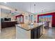 Functional kitchen island with granite countertop, stainless steel sink, seating, and an open view into the living room at 2422 W Maya Way, Phoenix, AZ 85085