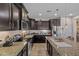 Stylish kitchen with dark cabinets, granite countertops, stainless steel appliances, and an island with a double sink at 2422 W Maya Way, Phoenix, AZ 85085