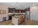 Modern kitchen featuring granite countertops, dark wood cabinets, stainless steel appliances, and a convenient center island at 2422 W Maya Way, Phoenix, AZ 85085