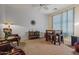 A living room with carpet flooring, a ceiling fan, and a chair near a window at 2422 W Maya Way, Phoenix, AZ 85085