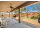 Covered patio features a ceiling fan, white wicker furniture and a well-manicured desert landscape at 2422 W Maya Way, Phoenix, AZ 85085