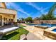 Spacious backyard featuring a covered patio, outdoor seating, a pool, an outdoor kitchen, and lounge chairs at 2460 E Crescent Way, Gilbert, AZ 85298