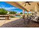 Beautiful backyard with a covered patio, outdoor seating, a pool, an outdoor kitchen, and lush landscaping at 2460 E Crescent Way, Gilbert, AZ 85298
