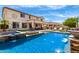 Gorgeous backyard featuring a covered patio, outdoor seating, a pool, an outdoor kitchen, and lounge chairs at 2460 E Crescent Way, Gilbert, AZ 85298