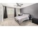 Simple bedroom with a window, ceiling fan, dark curtains, and a black metal bedframe at 2460 E Crescent Way, Gilbert, AZ 85298