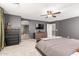 Well lit bedroom featuring hardwood dresser, ceiling fan and gray walls with views to bathroom at 2460 E Crescent Way, Gilbert, AZ 85298
