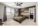 Bedroom with rustic wood accent wall, carpet floors, ceiling fan and bright window with blinds at 2460 E Crescent Way, Gilbert, AZ 85298