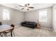 Well-lit bedroom featuring a loveseat, table, and ceiling fan at 2460 E Crescent Way, Gilbert, AZ 85298