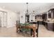 Open-concept dining area with a wooden table and black and green chairs adjacent to the kitchen at 2460 E Crescent Way, Gilbert, AZ 85298