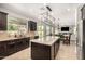 Bright, open kitchen featuring dark cabinetry, stainless steel appliances, and seamless views to the backyard and living room at 2460 E Crescent Way, Gilbert, AZ 85298