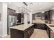 Spacious kitchen featuring dark cabinets, stainless steel appliances, and a large center island with granite countertops at 2460 E Crescent Way, Gilbert, AZ 85298